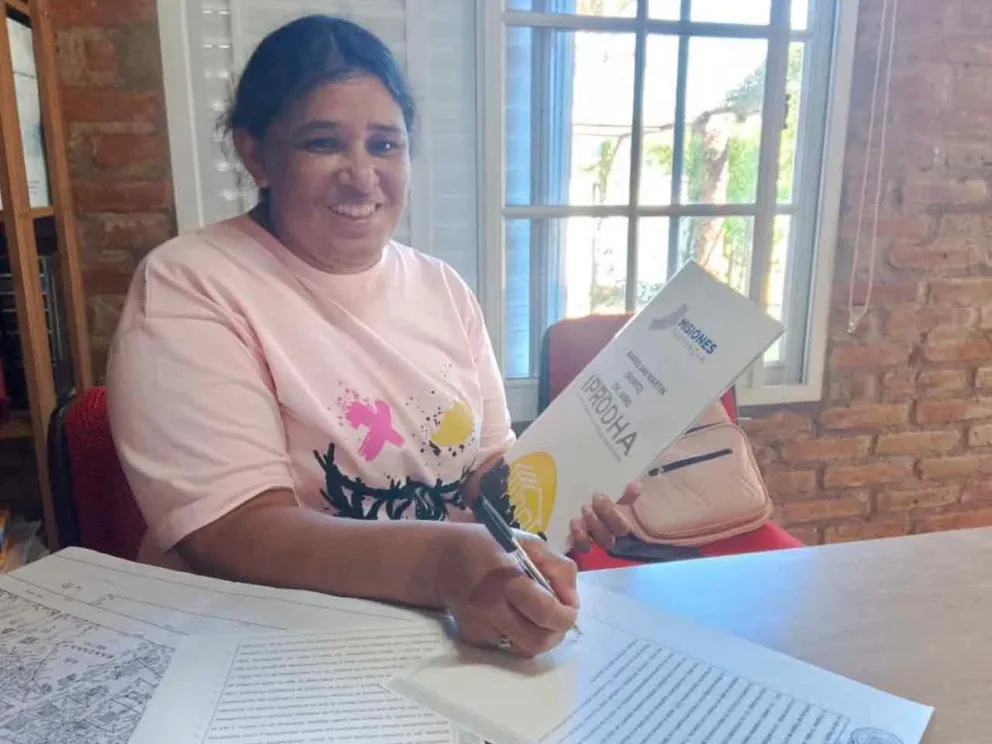 Beneficiaria firma el título de propiedad