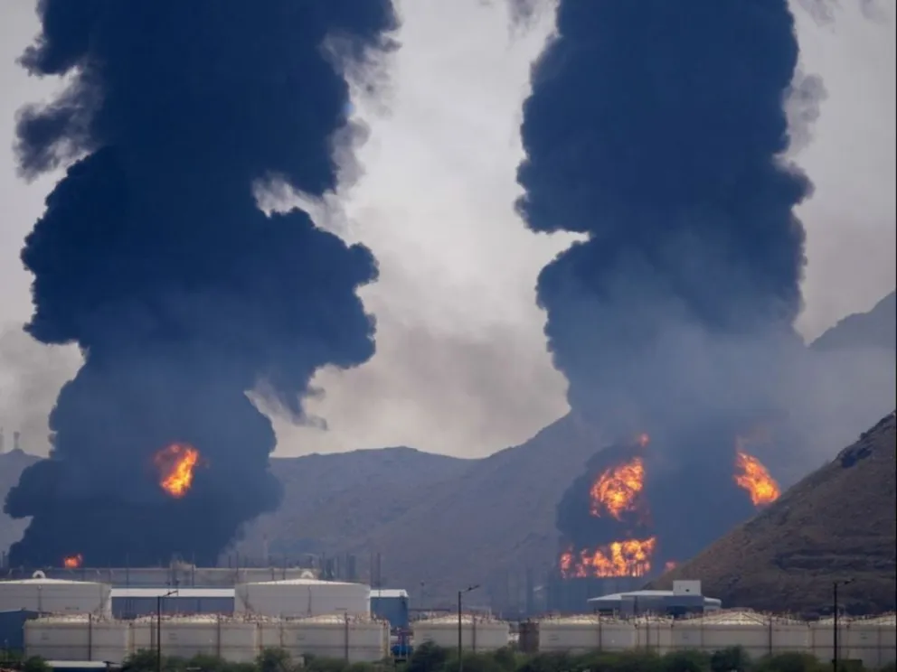 Una llamarada y una columna de humo se elevan tras el impacto de los restos de un dron iraní interceptado contra una instalación petrolera en Fujairah, Emiratos Árabes Unidos, el 14 de marzo de 2026.