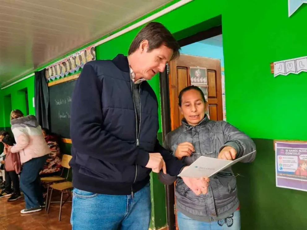 Héctor Rojas Decut junto a una vecina en el  operativo