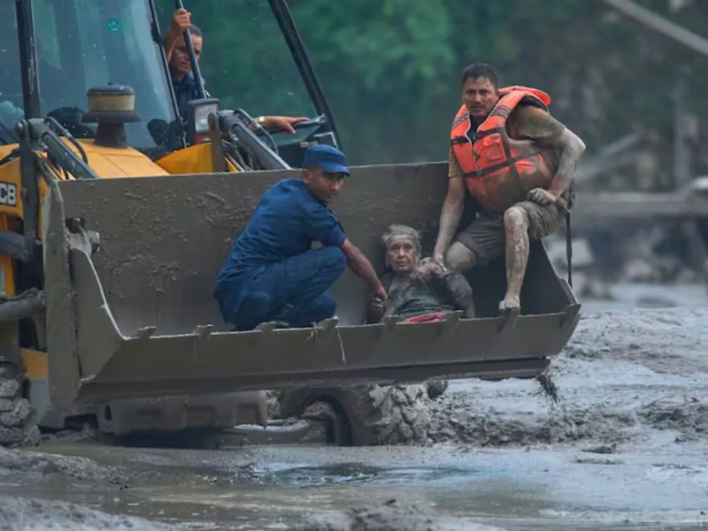 Los rescatistas utilizan una excavadora para trasladar a salvo a una víctima de las inundaciones repentinas a lo largo del río Trishuli, en el distrito de Nuwakot, Nepal