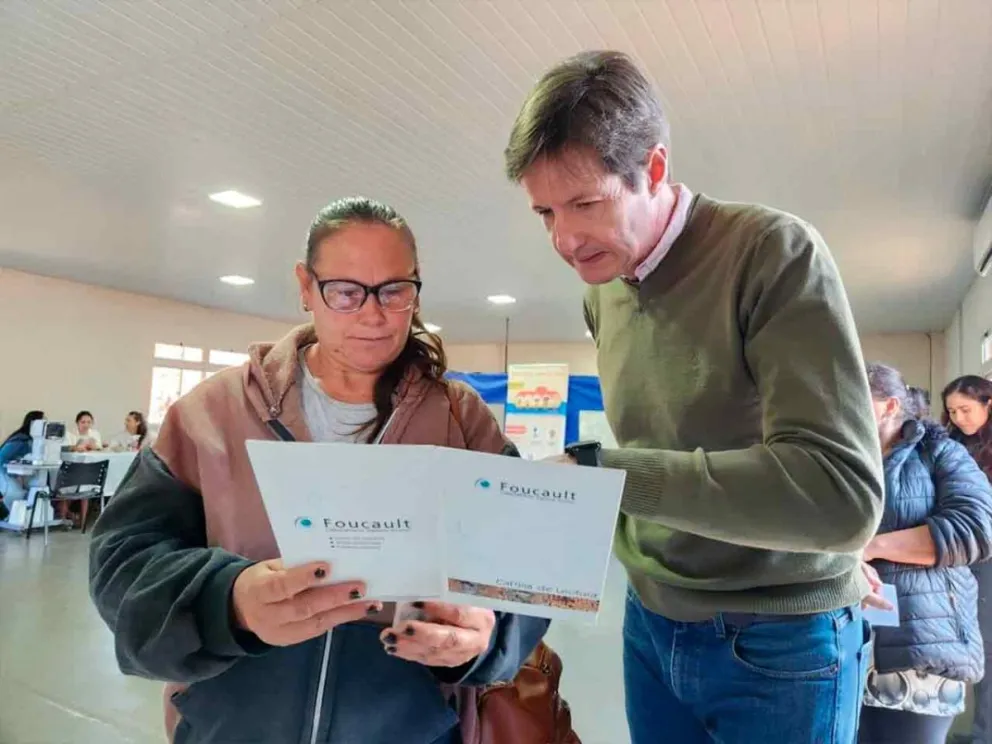 Héctor Rojas Decut junto a una vecina en el operativo