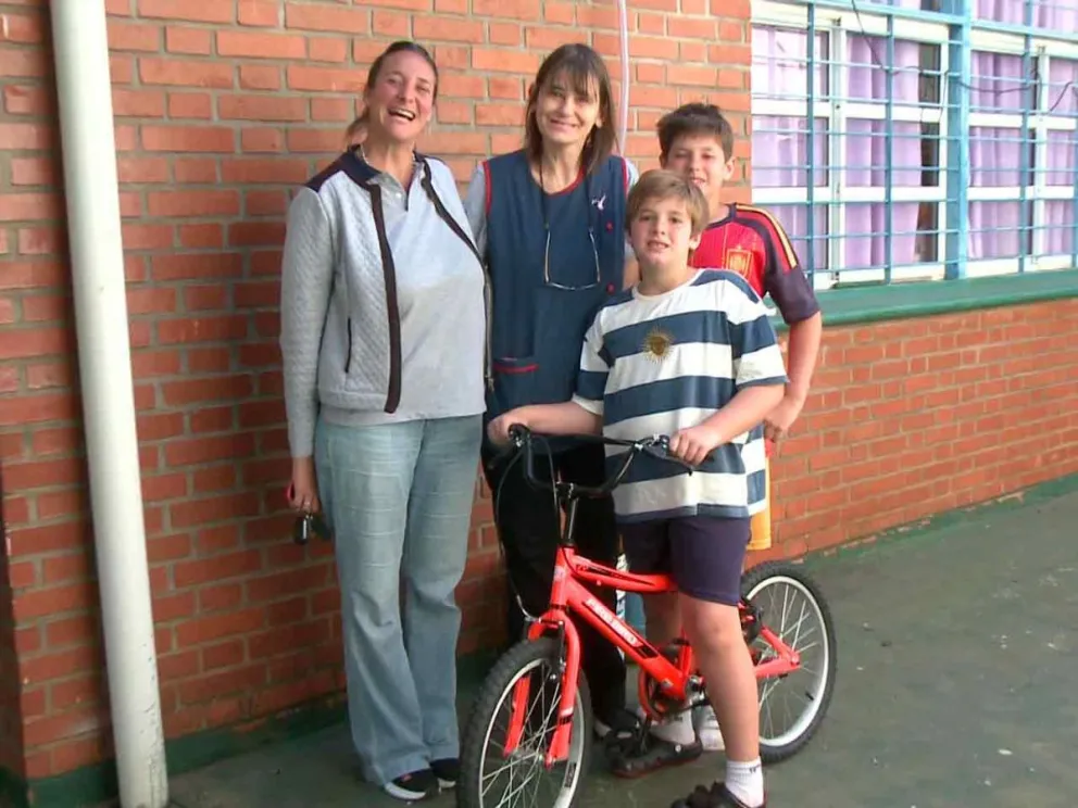 Joaquín y su bici-premio junto a la dire Marlene y su mamá